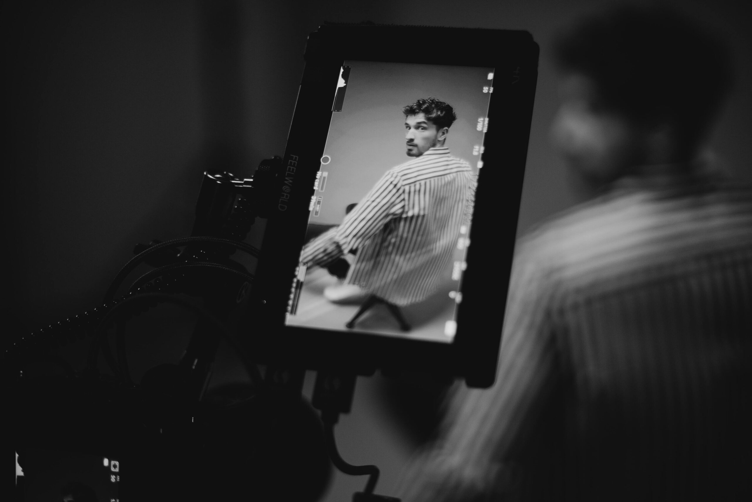 A monochrome portrait of a man displayed on a camera monitor with a focus on artistic expression.